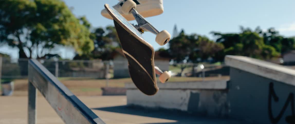 The skateboard flips during a jump over the handrail