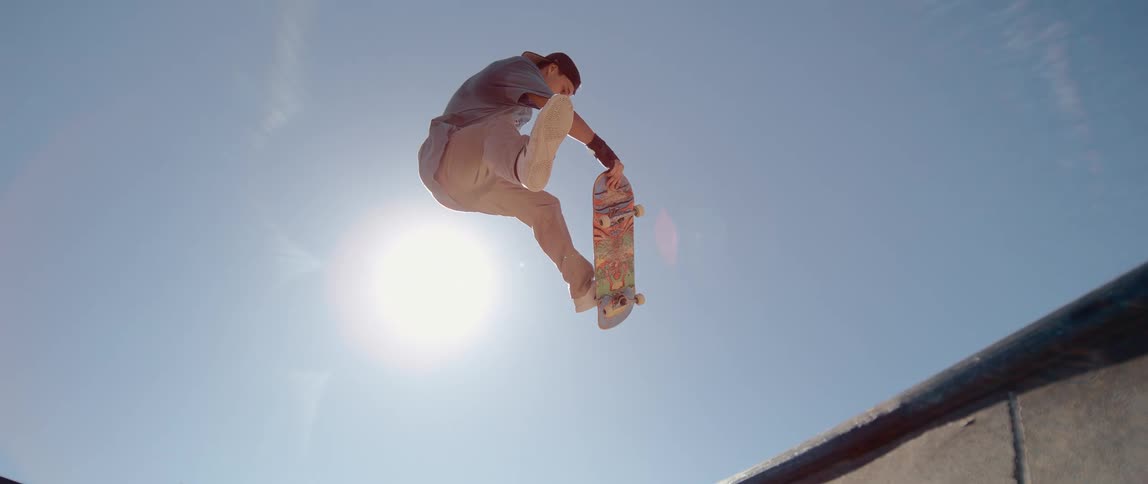 A teenage boy is up in the air doing a trick on his skateboard