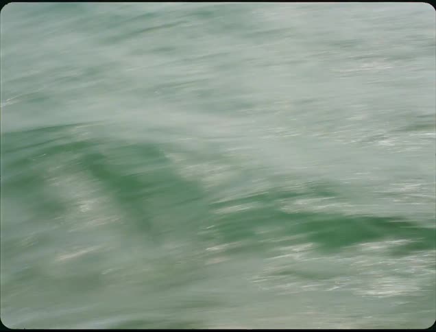 A rocky shoreline with waves crashing against the rocks at midday