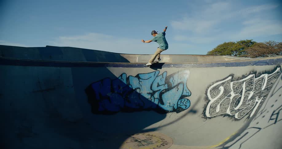 A young male skateboards and performs a trick at a skate park