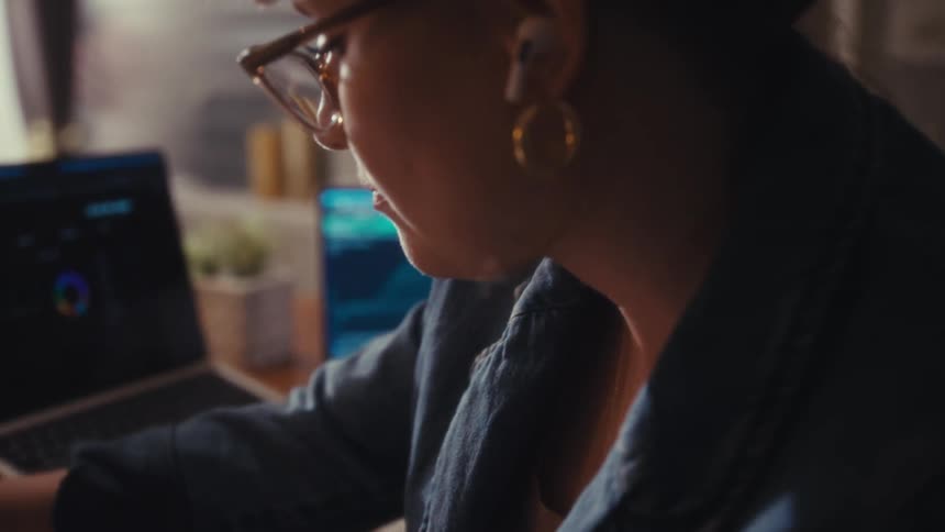The woman is writing at her desk