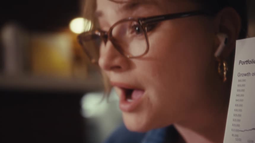 The woman is talking and pointing at a piece of paper