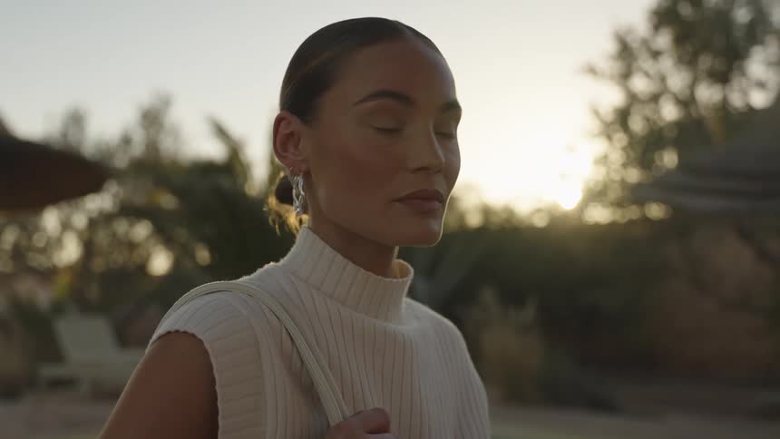 A woman with full makeup is standing outside