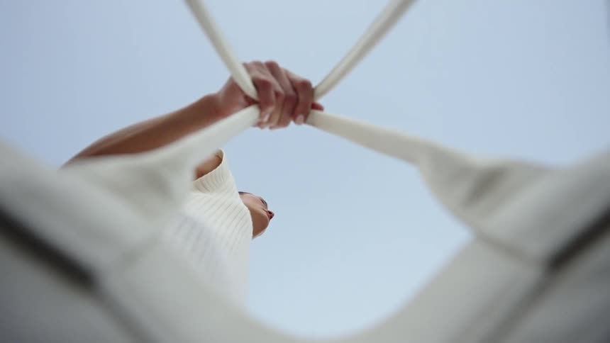 The woman is carrying a white handbag