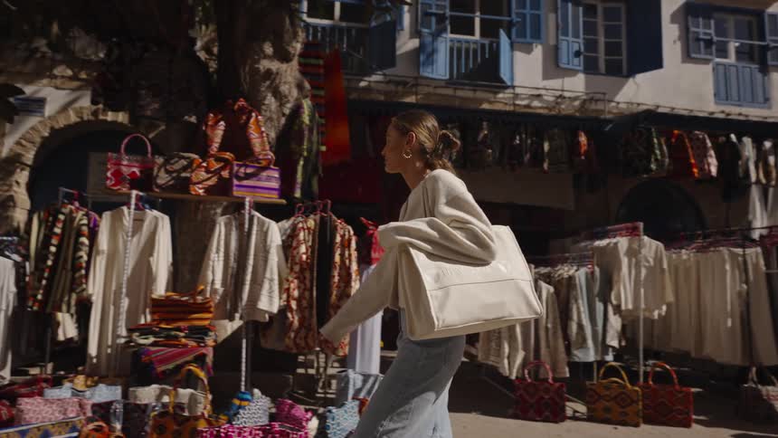 The woman walks past the outdoor clothing store