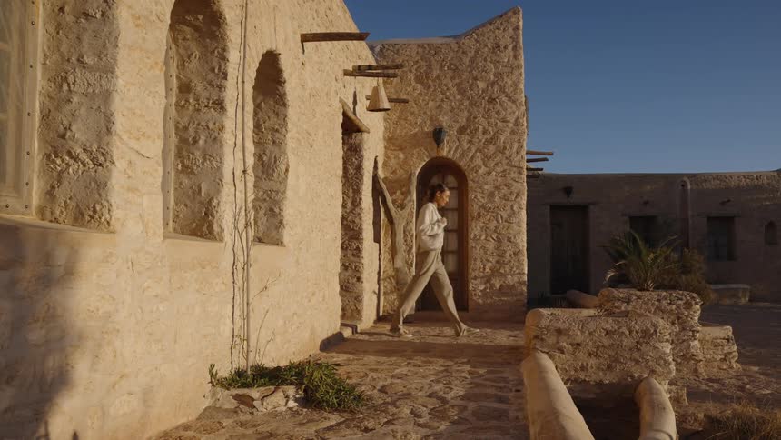 A woman walking outdoors on a sunny day