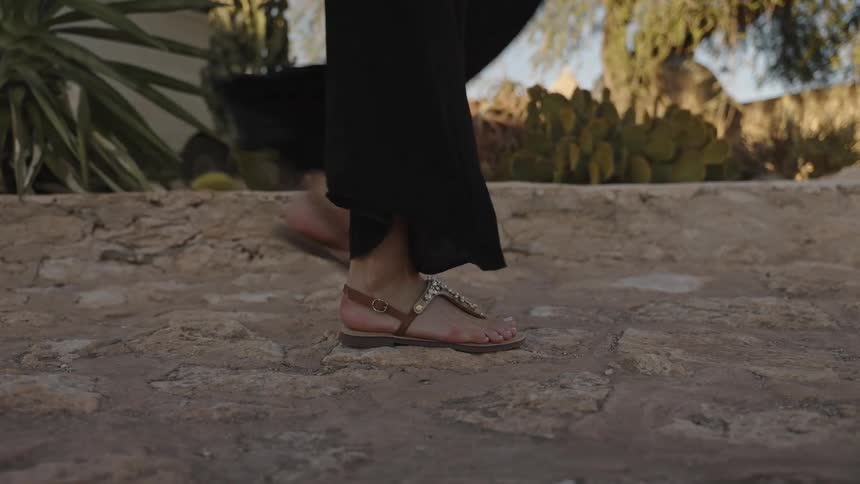 Feet walking on a stone surface in an outdoor area