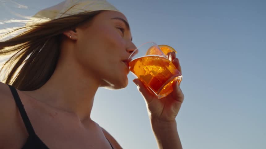 Woman standing outside sips her drink