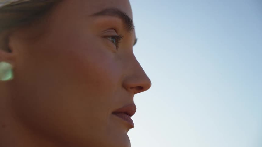 Profile of a female face with an earring outdoors during day time