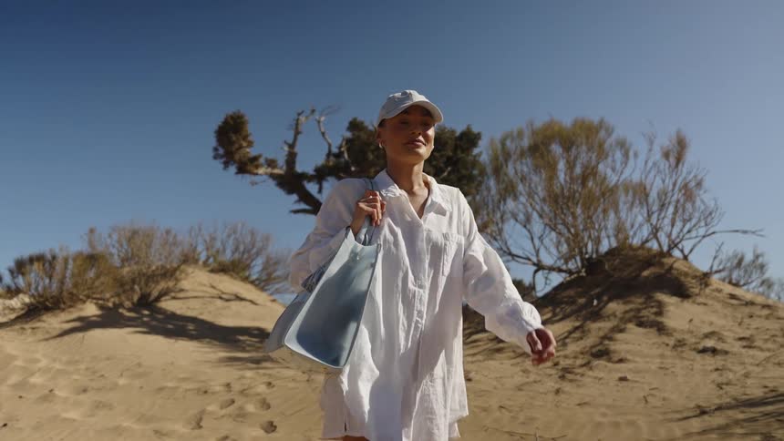 The woman walks towards the beach