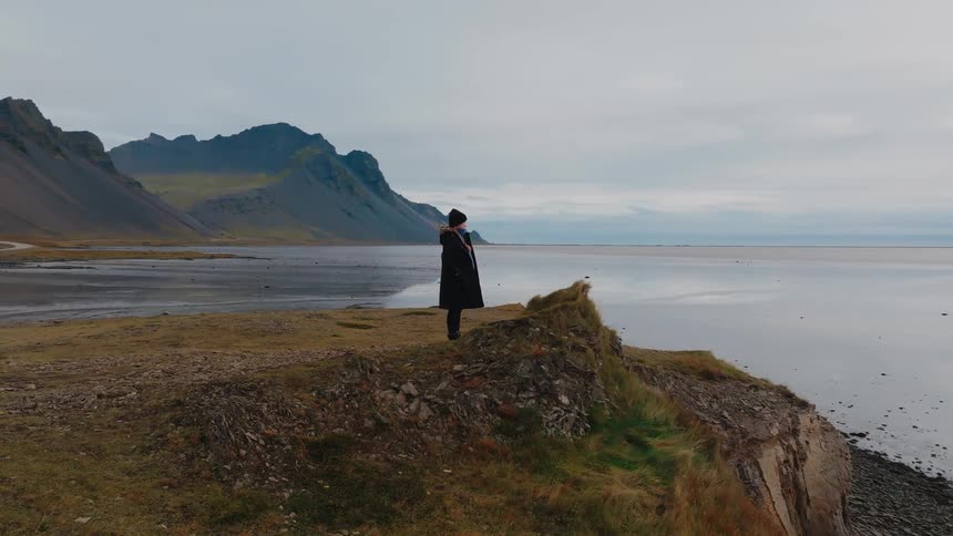 A woman standing outdoors on a cliff