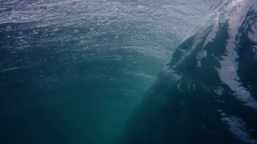An underwater view of a wave breaking and exerting a downward force