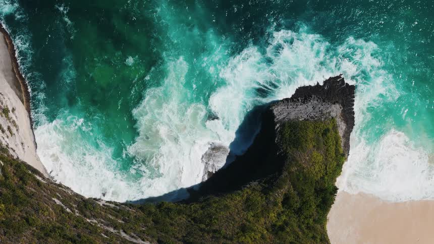 Dark blue water sends waves crashing into beaches below cliffs