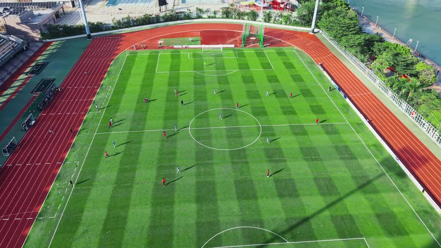 Soccer players are running on a field in a stadium in a city