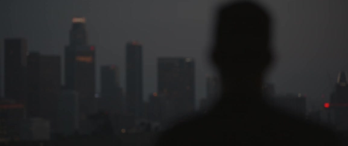 A man looks at city skyscrapers at night