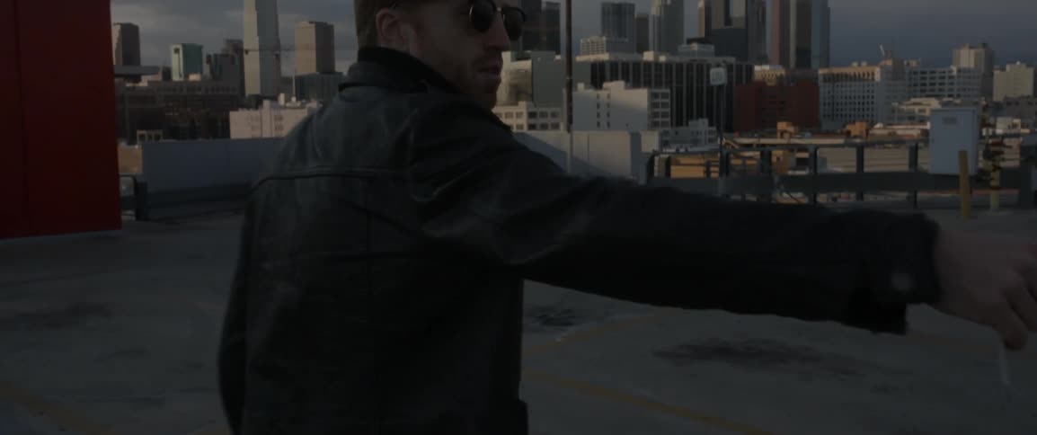 A man looks back and remotely locks a car before walking away