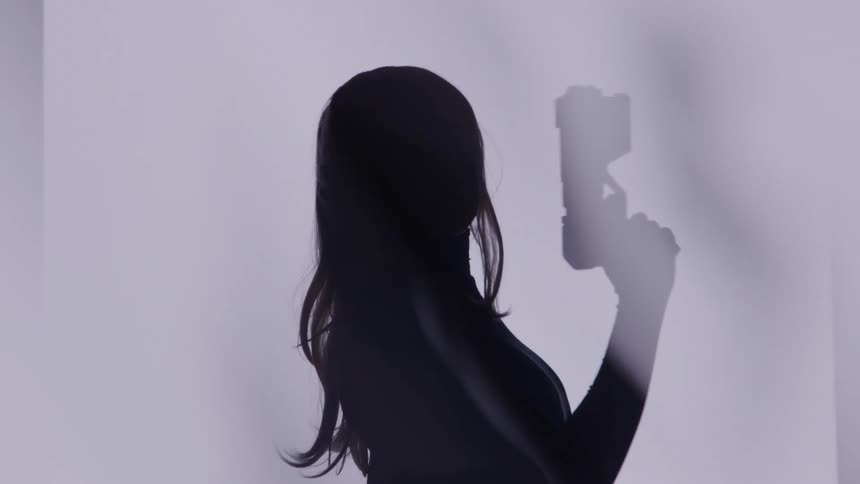 The woman swings the gun around