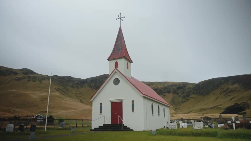 Remote chapel with steeple in rural countryside surrounded by hillside
