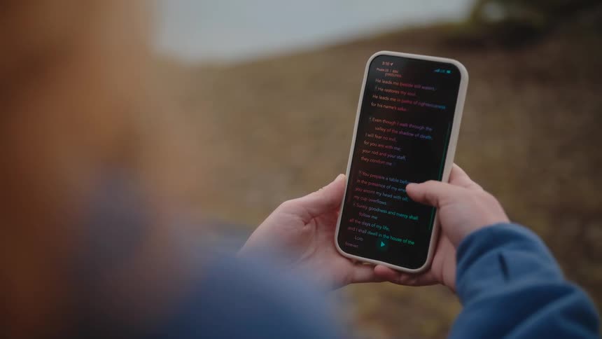 Woman holds her phone and moves her thumb across the screen as she scrolls