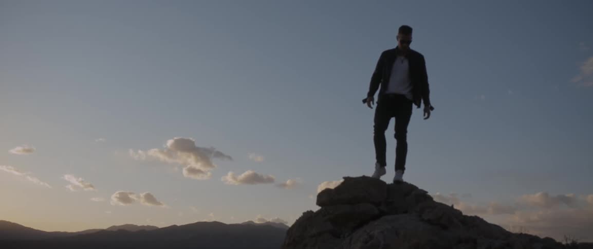 A man walking down the top of a mountain