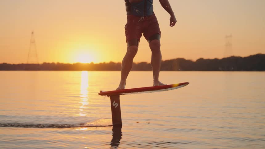 The man is kite surfing on the lake