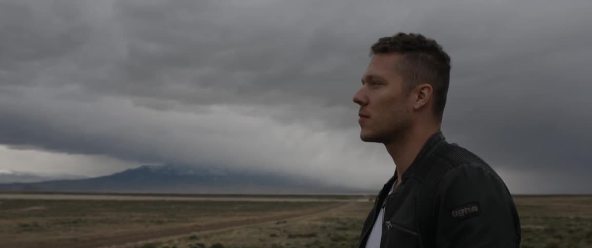A man looks out over a long field