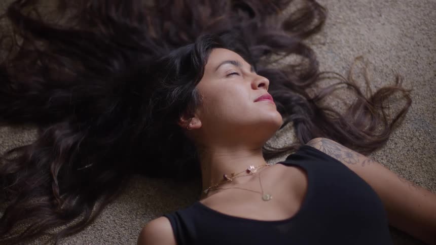 The woman is laying on the carpet