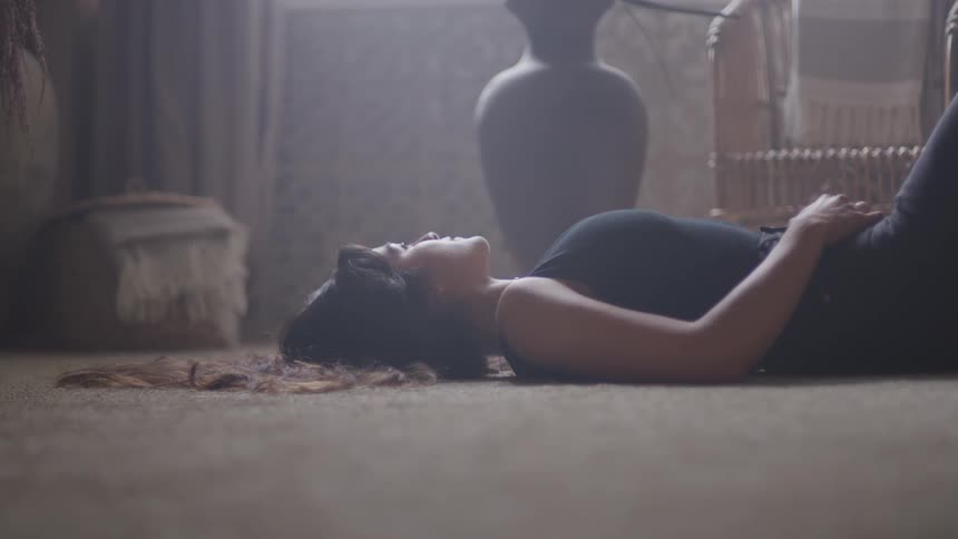 Woman wearing black clothes lying down on the floor indoors during day time