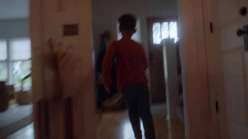 A crying boy runs down the hallway towards his mothers lap