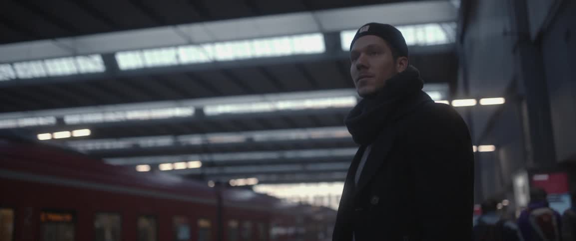 A man waits at a train station
