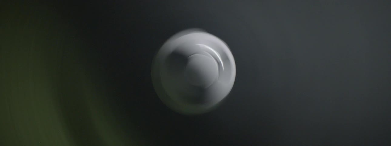 Black and white soccer ball floating in dark background with lit smoke