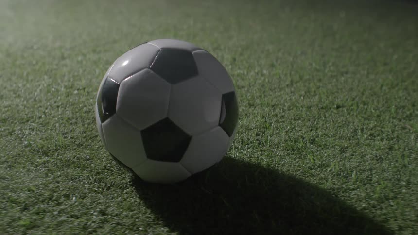 Sunlight shines on a soccer ball on the turf