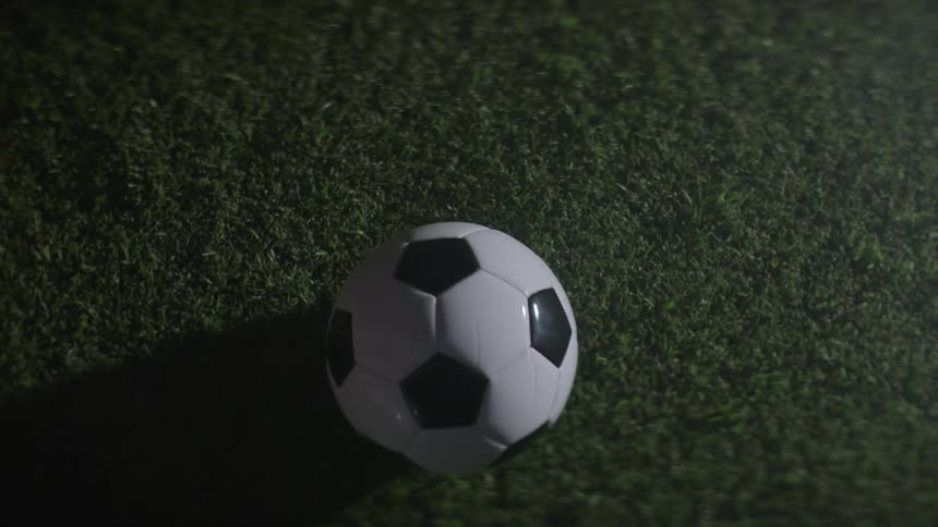 A soccer ball is dropped onto the grass