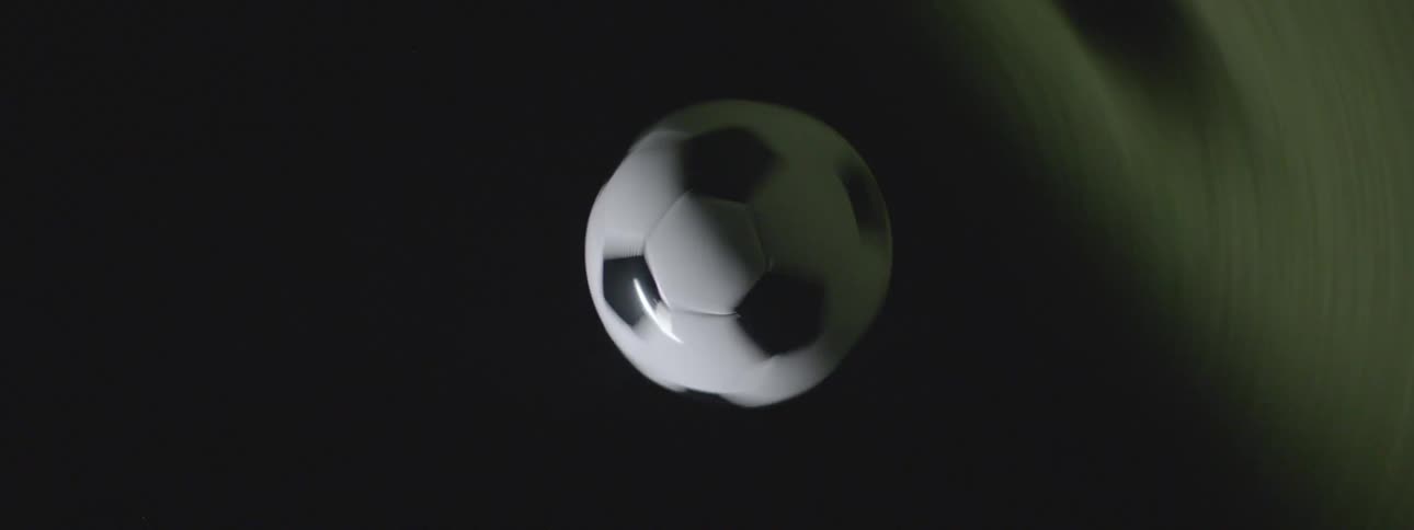 Soccer ball suspended in the air against a completely dark background