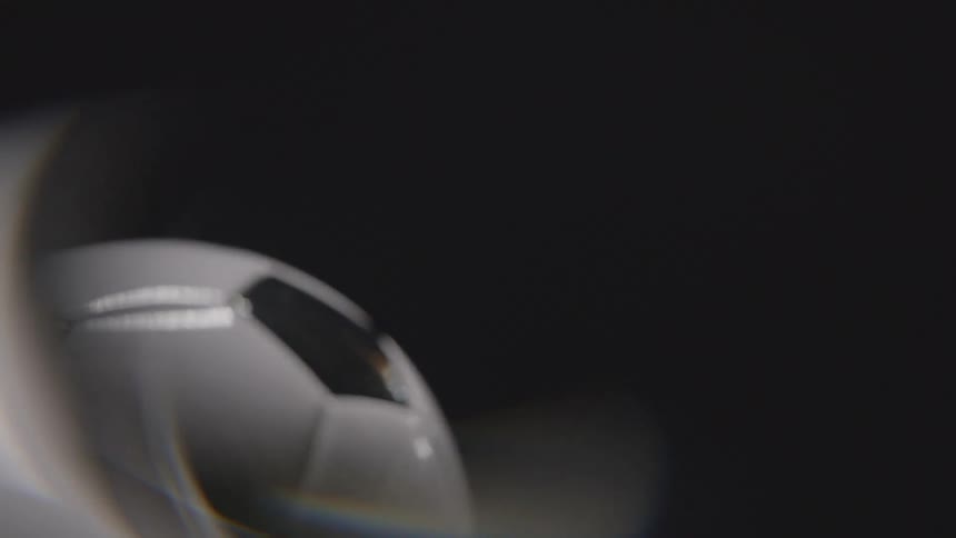 fulbol soccer ball resting on green grass in with abstract halo