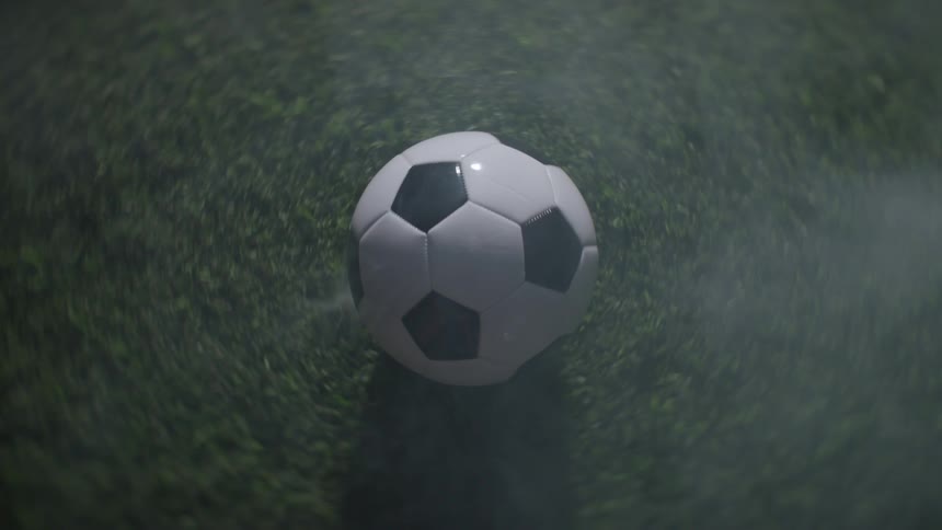 The soccer ball spins on the grass