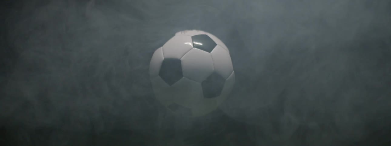 This video shows a soccer ball suspended in the air slowly rotating within a smoky or misty atmosphere the ball is black and white and the watermark filmsupply is visible across the center