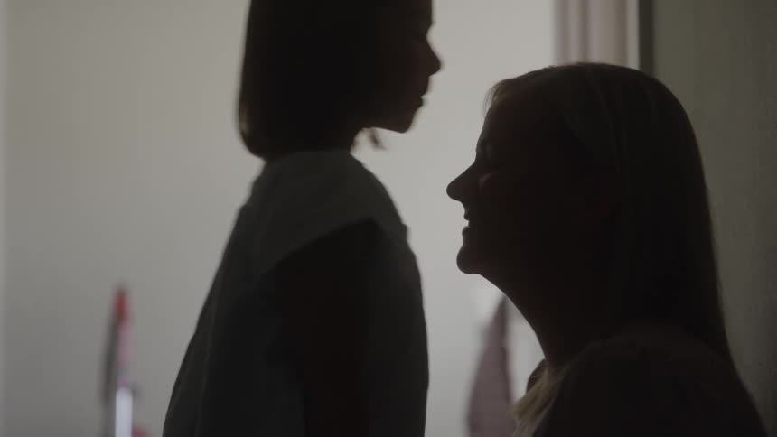 Daughter kisses her mothers forehead in a tender moment
