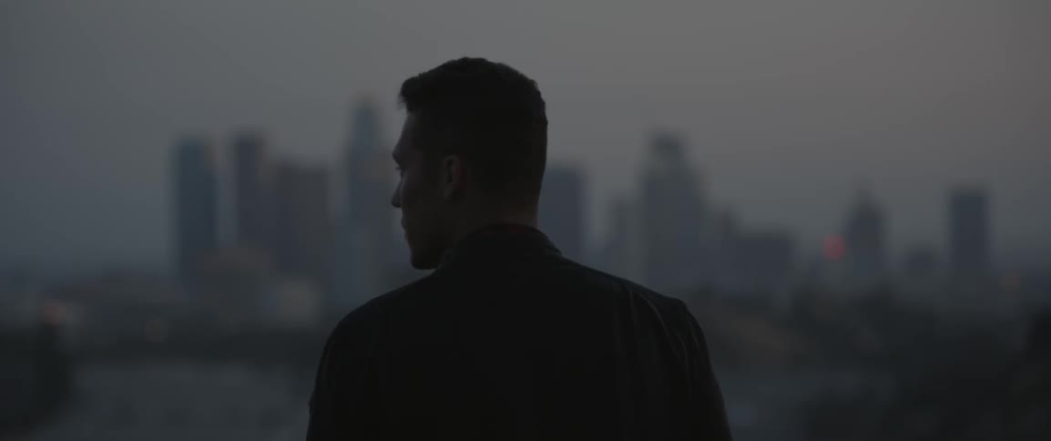 A man is looking over a city then to the side
