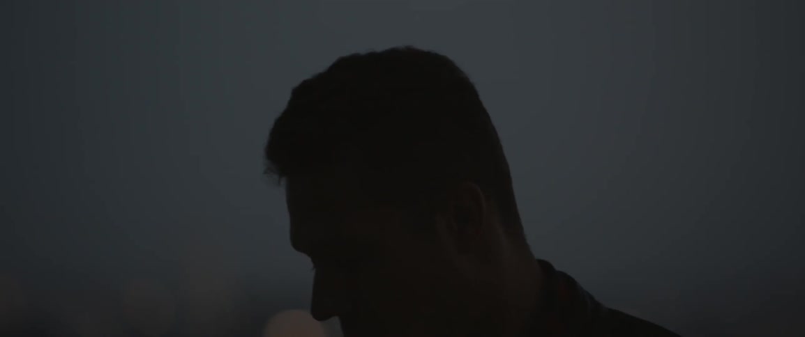 A man looks out over a city and turns around