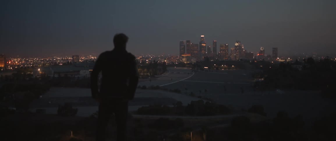 Man looking at a big-city skyline at night