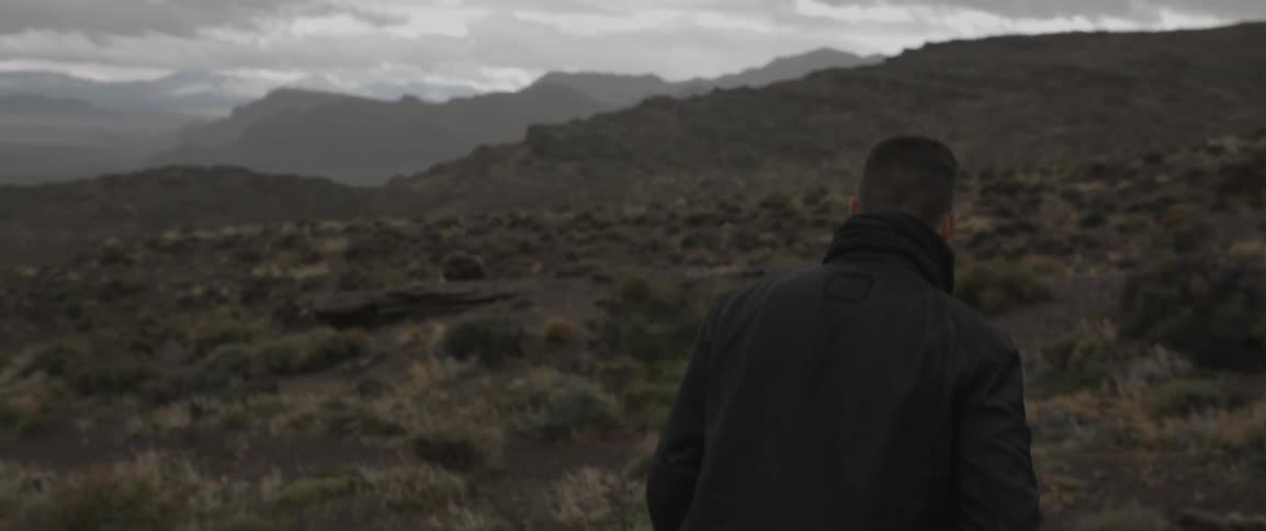 A man walks in the mountains on a cloudy day