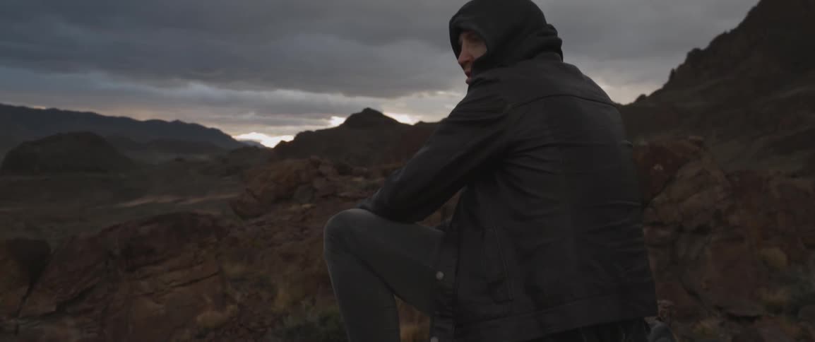 A man sits on rocks on a mountain