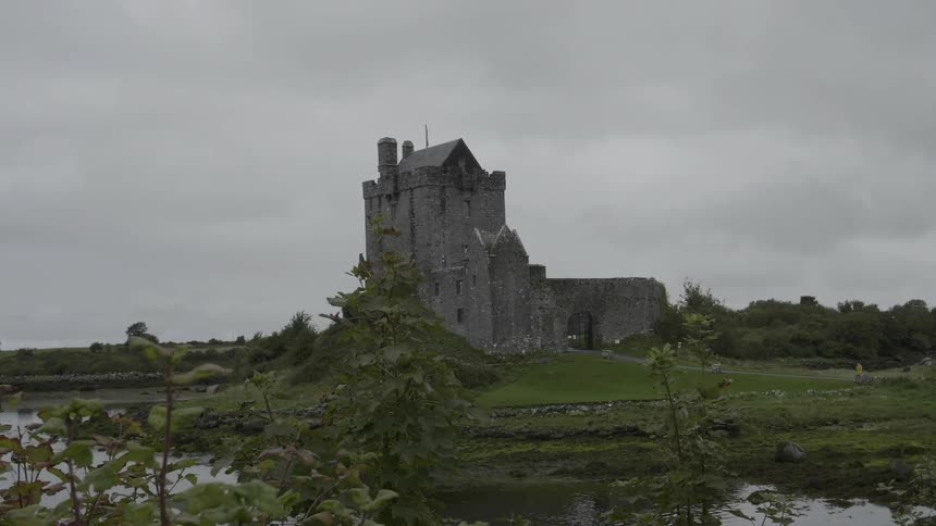 A large building surrounded by water on a cloudy day at dusk