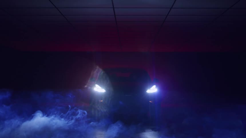 Car with headlights on emerging from dark smoky space with blue and red lighting