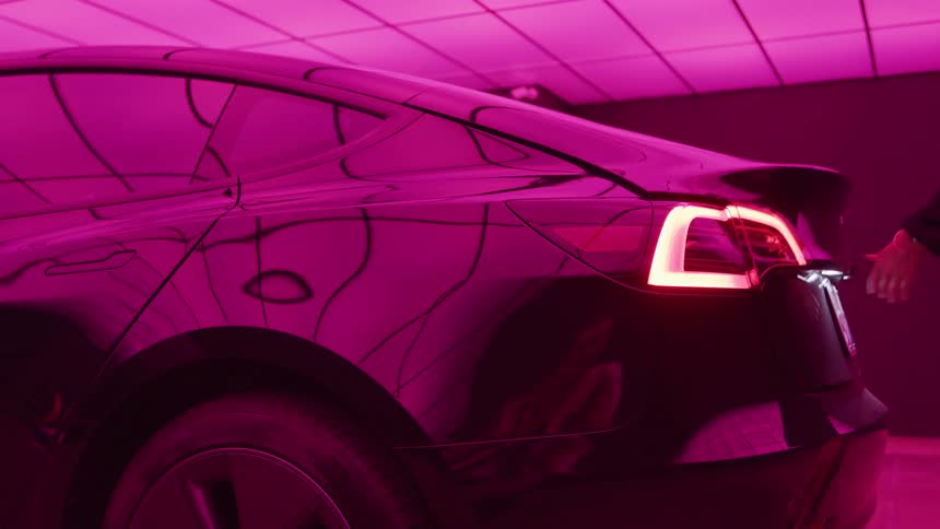 Woman opening the trunk of her car in a brightly lit garage