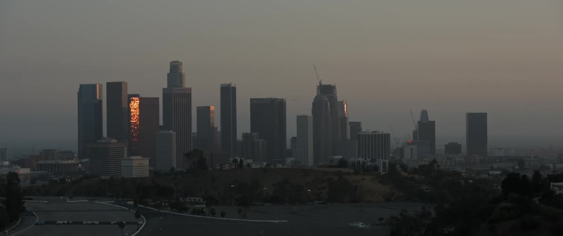 The sunset reflects on the skyscrapers of a city skyline