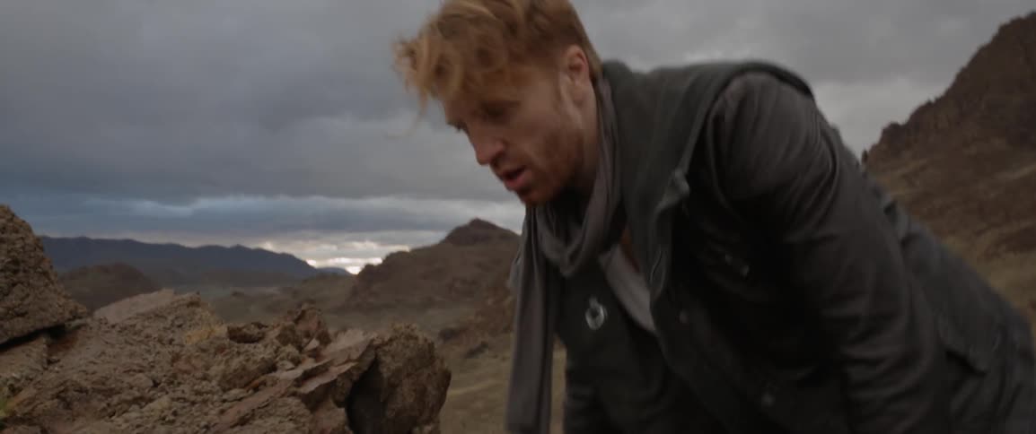 A man is climbing over rocks worried