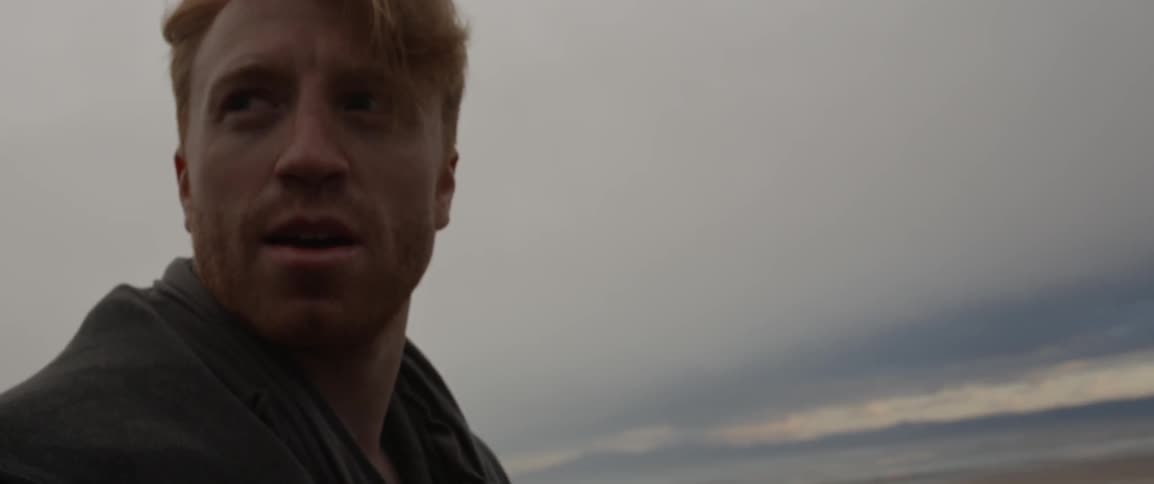 Man looks across a vast plain on a cloudy day
