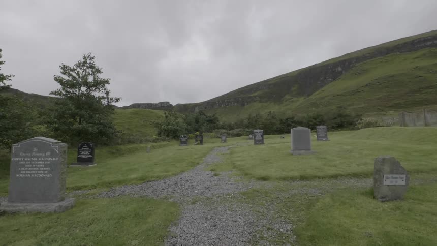 Headstones are shown in a cemetery